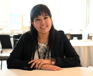 Victoria Fernandez smiles at the camera while sitting in a conference room.