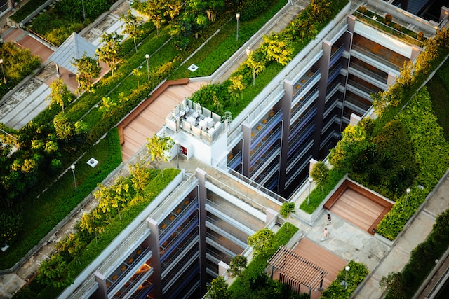 Aerial image of a multi-storey building with a green roof. Two people can be seen walking on a path on the roof.