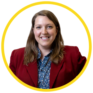Caitlin Peace-Williams sourit pour une photo. Leur visage est encadré par un cercle jaune.