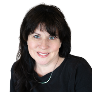 Le français suit. A picture of a person with long black hair wearing a black shirt smiling at the camera, framed by a blue circle.Photo d'une personne aux longs cheveux noirs, vêtue d'une chemise noire, souriant à l'appareil photo, encadrée d'un cercle bleu.