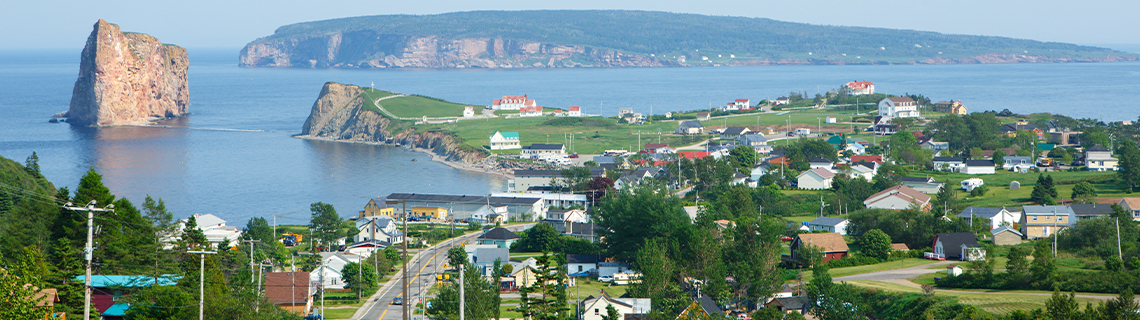 Landscape view of a coastal community with cliffs in the background.