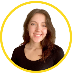 Le français suit A picture of a person with brown hair wearing a black top smiling at the camera, framed by a yellow circle. La photo d'une personne aux cheveux bruns, vêtue d'un haut noir, souriant à l'appareil photo, encadrée d'un cercle jaune.