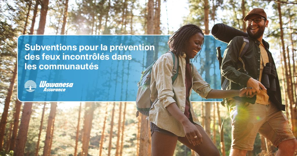 Une image de trois randonneurs dans une forêt boisée, avec un logo à gauche d'eux avec le texte 'Subventions communautaires pour la prévention des incendies de forêt'.