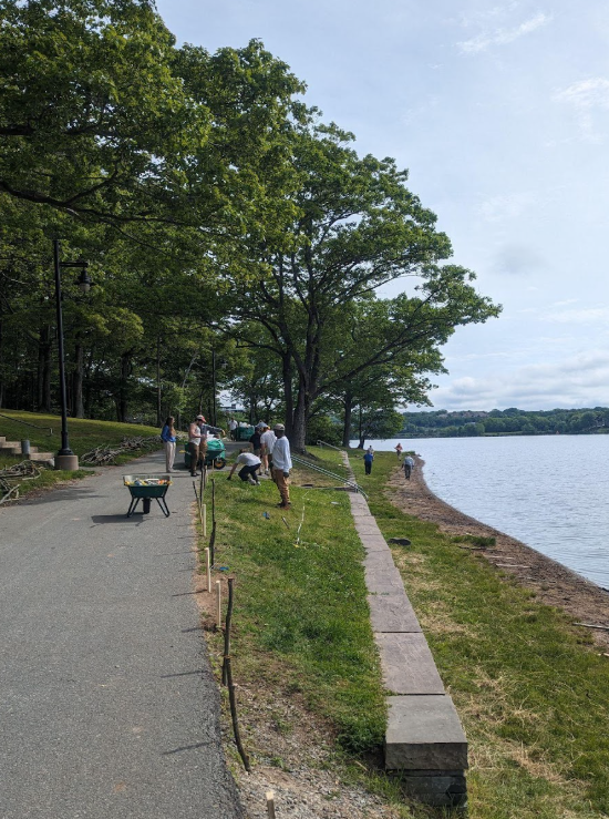 Le français suit. A view of the walking trail and shoreline of Birch Cove Beach in Nova Scotia. Several people are walking along the coast. Vue du sentier pédestre et du littoral de Birch Cove Beach, en Nouvelle-Écosse. Plusieurs personnes marchent le long de la côte.