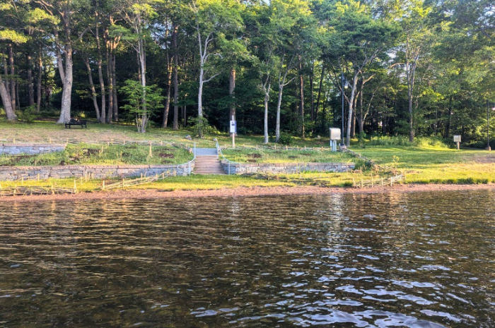 Le français suit. A view of the waterfront of Birch Cove beach in Nova Scotia. Sections of shoreline are roped off where work to restore native plants has been taking place. Vue du front de mer de la plage Birch Cove en Nouvelle-Écosse. Certaines sections du littoral sont délimitées par des cordes, car des travaux de restauration des plantes indigènes y sont en cours.