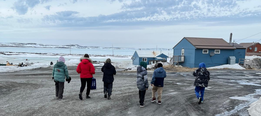 Six personnes s'éloignant de la caméra en direction de la côte en hiver