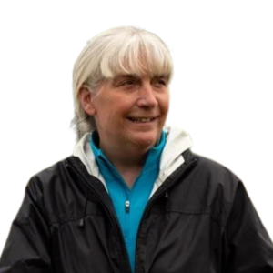 Le français suit A picture of a person with white hair in a ponytail wearing a black windbreaker and smiling, framed by a yellow circle. Le français suit Photo d'une personne aux cheveux blancs attachés en queue de cheval, vêtue d'un coupe-vent noir et souriante, encadrée par un cercle jaune. 